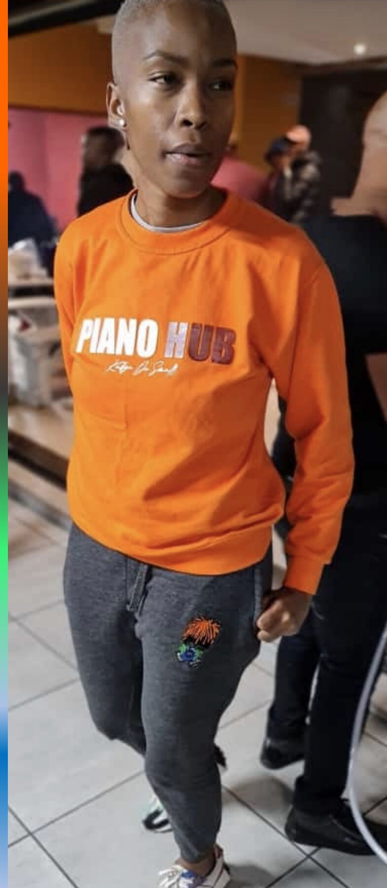 Orange hoodie with dripping THE ARTISTIC graphic on the back.